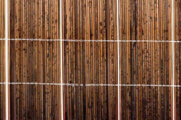 Old wooden sun-bleached blinds on the window. The morning sun shines through the blinds consisting...
