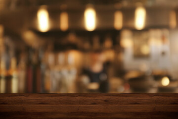 Top wood table blur chef cooking in bar restaurant background.For create product display or design...