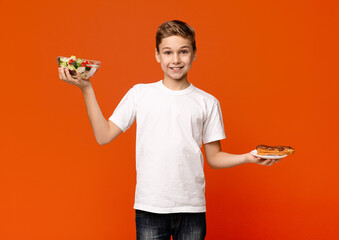 Teenage boy comparing vegetable salad and eclair on hands