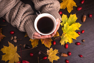 autumn mood. cup of coffee in hands. fallen leaves