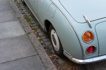 Close-up of a popular and fashionable two seater coupe motor car seen parked by a kerb in a City residential area. The classic-styled rear light cluster is shown.