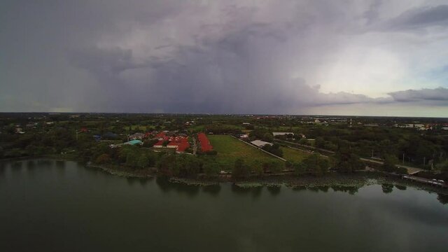 Aerial view above the lake of rain storm with heavy raining above villages and rice paddy fields, Krajub reservoir, Nong Kop District, Ban Pong, Ratchaburi, Thailand.