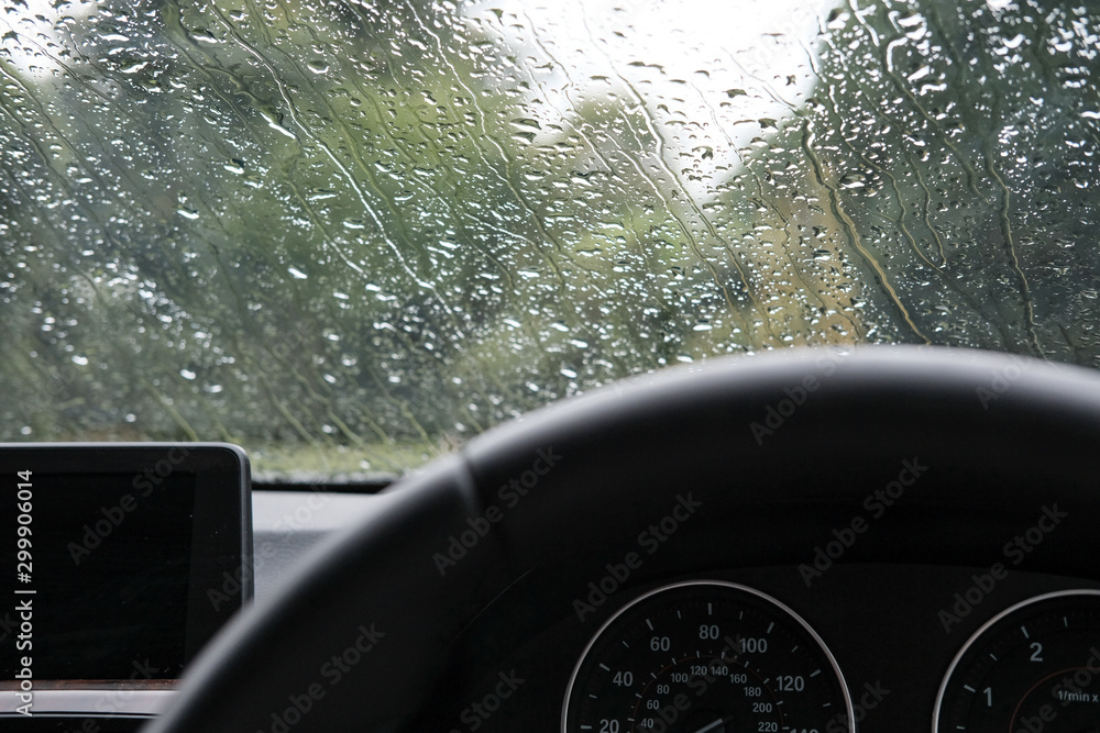 Wall mural Drivers view of a heavy downpour seen will parking up in a luxury, german-built sports car.