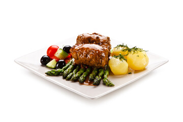Wrapped pork chops with potatoes and asparagus on white background
