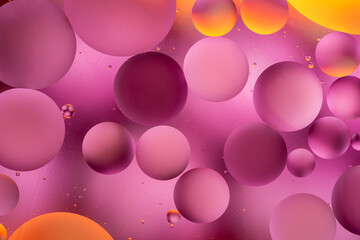 bright oily drops in water with colorful background, close-up 