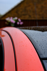 Newly built hybrid motor vehicle showing detail of the rear roofline, seen just after a rain shower.