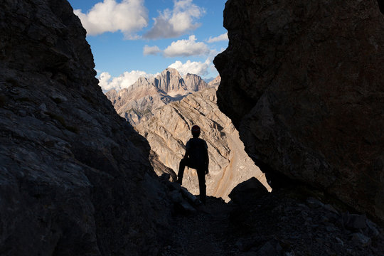 A hiker observes the Gran Vernel group in a small fork along the Bepi Zac High Trail, Costabella Ridge, Marmolada group, Dolomites, Moena, Fassa Valley, Trento province, Trentino-Alto Adige, Italy.