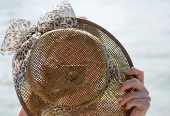 young woman with straw hat taking artistic photo