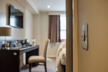 Isolated view of a metal light switch in the office position located in an apartment bedroom. The...