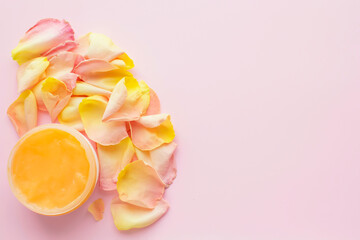 Open jar of cosmetic cream and rose petals on pink background. Concept of organic spa cosmetics. Flat lay, top view, copy space.	