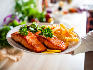 Fried salmon, French fries and vegetables