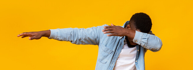 Man throwing dab, making internet meme pose on yellow background