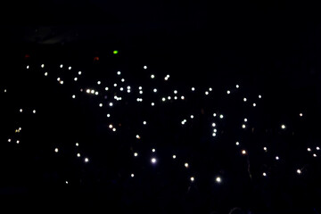 Lights and camera flash at concert, show, hall.