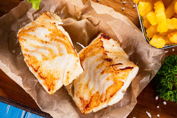 Fish dish - fried fish fillet with french fries and vegetables