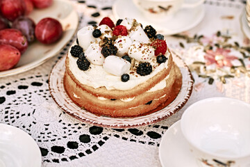 Homemade festive berry cake with souffle decorated with raspberries, blueberries, blackberries