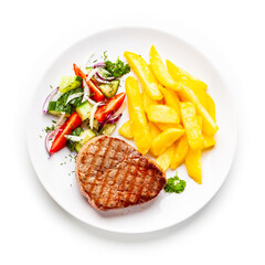 Grilled steaks, French fries and vegetables