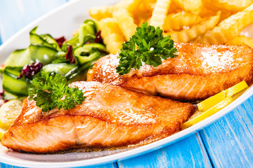 Fried salmon, French fries and vegetables