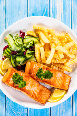 Fried salmon, French fries and vegetables