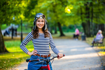 Woman standing with bike in city park