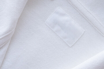 Fototapeta na wymiar Blank white clothes label on new shirt background