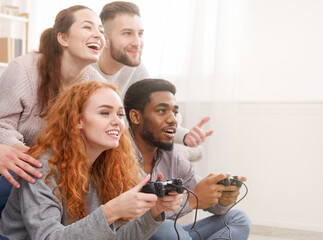 Obraz premium Friends competing in video games, having fun at home