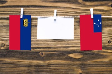 Hanging flags of Liechtenstein and Samoa attached to rope with clothes pins with copy space on...