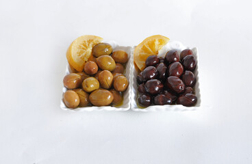 Black and green olives in branch on white background.