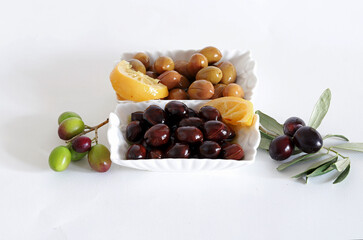 Black and green olives in branch on white background.