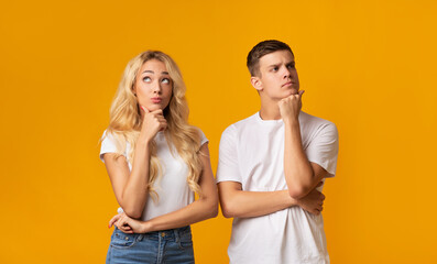 Portrait of thoughtful young couple on yellow background
