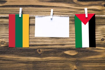 Hanging flags of Lithuania and Palestine attached to rope with clothes pins with copy space on...
