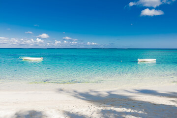 Tropical beach with transparent ocean and boat in Mauritius