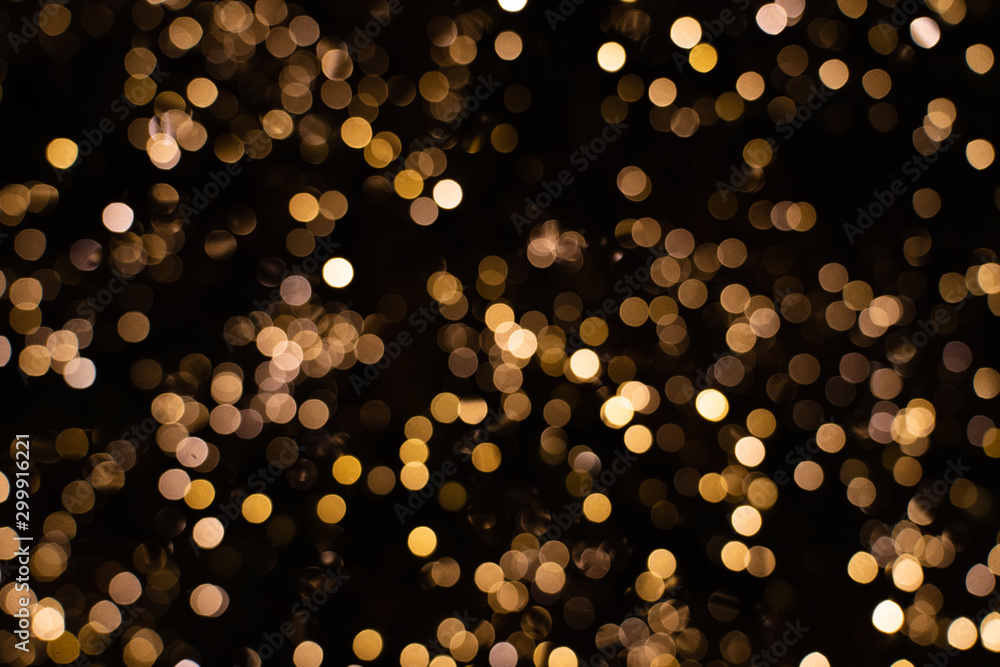 Wall mural blurry golden and white fairy string lights in dark night creating beautiful bokeh effect with glowi