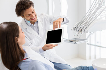 Fototapeta na wymiar Handsome dentist showing blank digital tablet screen