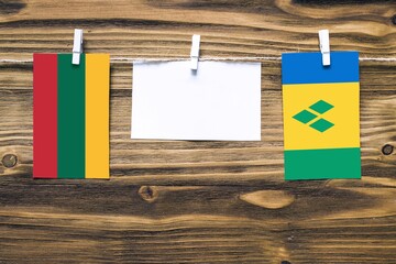 Hanging flags of Lithuania and Saint Vincent And The Grenadines attached to rope with clothes pins...