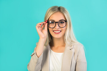 Fototapeta premium beautiful young woman in suit with glasses on a blue background