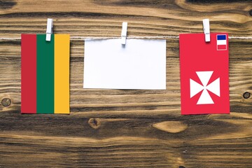 Hanging flags of Lithuania and Wallis And Futuna attached to rope with clothes pins with copy space...