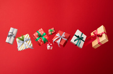 Christmas gifts boxes fly or fall on red background