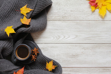 Grey cup of coffee, yellow fall leaves, plaid on white wooden table. Autumn background concept....