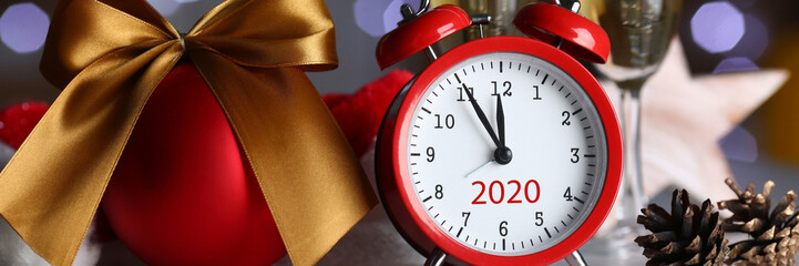 Red alarm clock and champagne goblet at office table