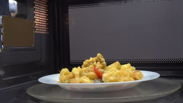 Making microwave meal. Macaroni and cheese in bowl microwaving top view. the bowl rotates in the microwave, around its axis, the movement.
