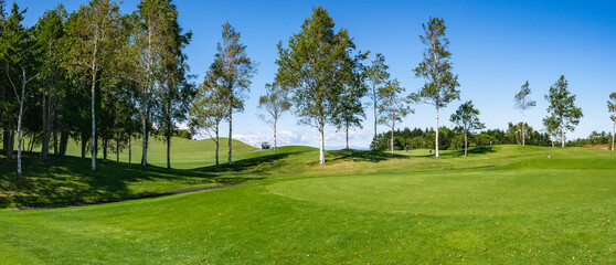 Obraz premium View of Golf Course with teeing area. Golf course with a rich green turf beautiful scenery.