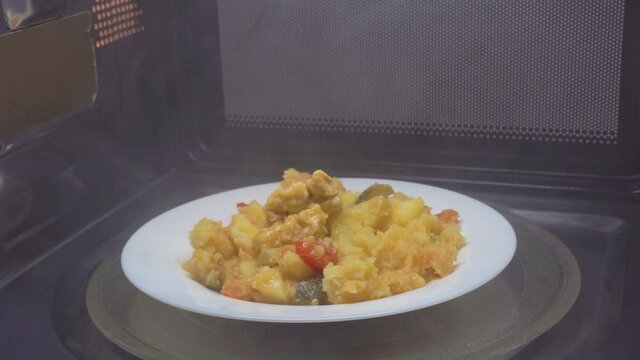Making microwave meal. Macaroni and cheese in bowl microwaving top view. the bowl rotates in the microwave, around its axis, the movement.