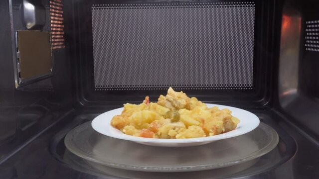Making microwave meal. Macaroni and cheese in bowl microwaving top view. the bowl rotates in the microwave, around its axis, the movement.