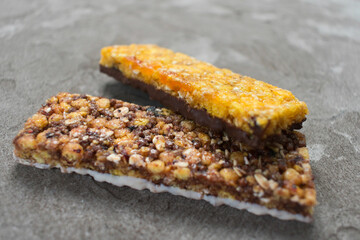 Two granola bars on a gray background. Close-up.