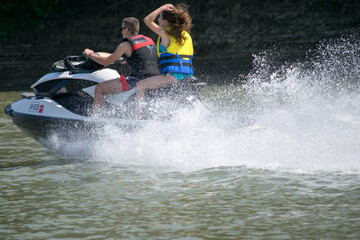 Fototapeta na wymiar young man and woman on a jetski at river
