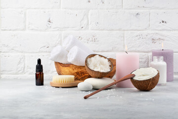Beautiful spa relax concept. Coconut scrub and milk, oil cream, brush for body massage, towels,...