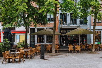 Old street with tables of cafe in historic city center of Antwerpen (Antwerp), Belgium. Cozy cityscape of Antwerp. Architecture and landmark of Antwerpen