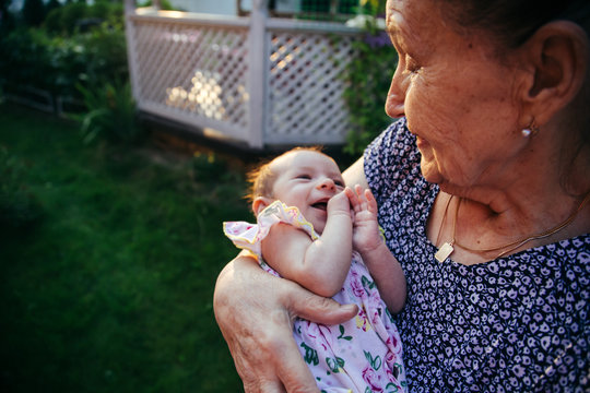 Heartwarming Photo Of A Family Album: Great-grandmother Holds In Her Arms A Little Granddaughter Who Smiles At Her 