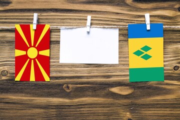 Hanging flags of Macedonia and Saint Vincent And The Grenadines attached to rope with clothes pins...