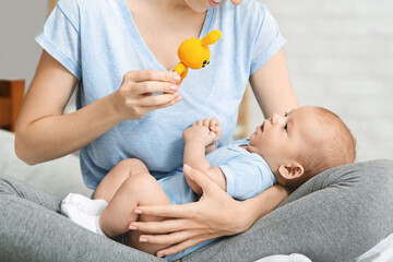 Mom holding developing toy playing with her newborn baby